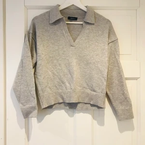 Grå V-formad stickad tröja - Använd ett fåtal gånger, mjuk och sticks inte :)