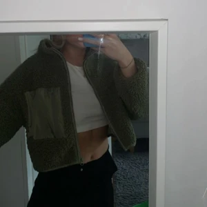 Grön croppad Teddy jacka - Säljer denna svin coola lilla jacka ifrån gina tricot, helt nyskick! Köpt för 400kr men slutsåld överallt! Xxs men sitter mer som en xs😍