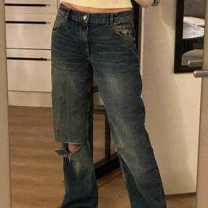 Midwaist jeans med hål på ena knät, endast använda 2 ggr! Har klippt av de i längden för att passa mig som är 1.70 lång! Sitter jättesnyggt oversized på mig som vanligtvis har stl 36 (de är i stl 40)👌 köpare betalar frakt på 66 kr