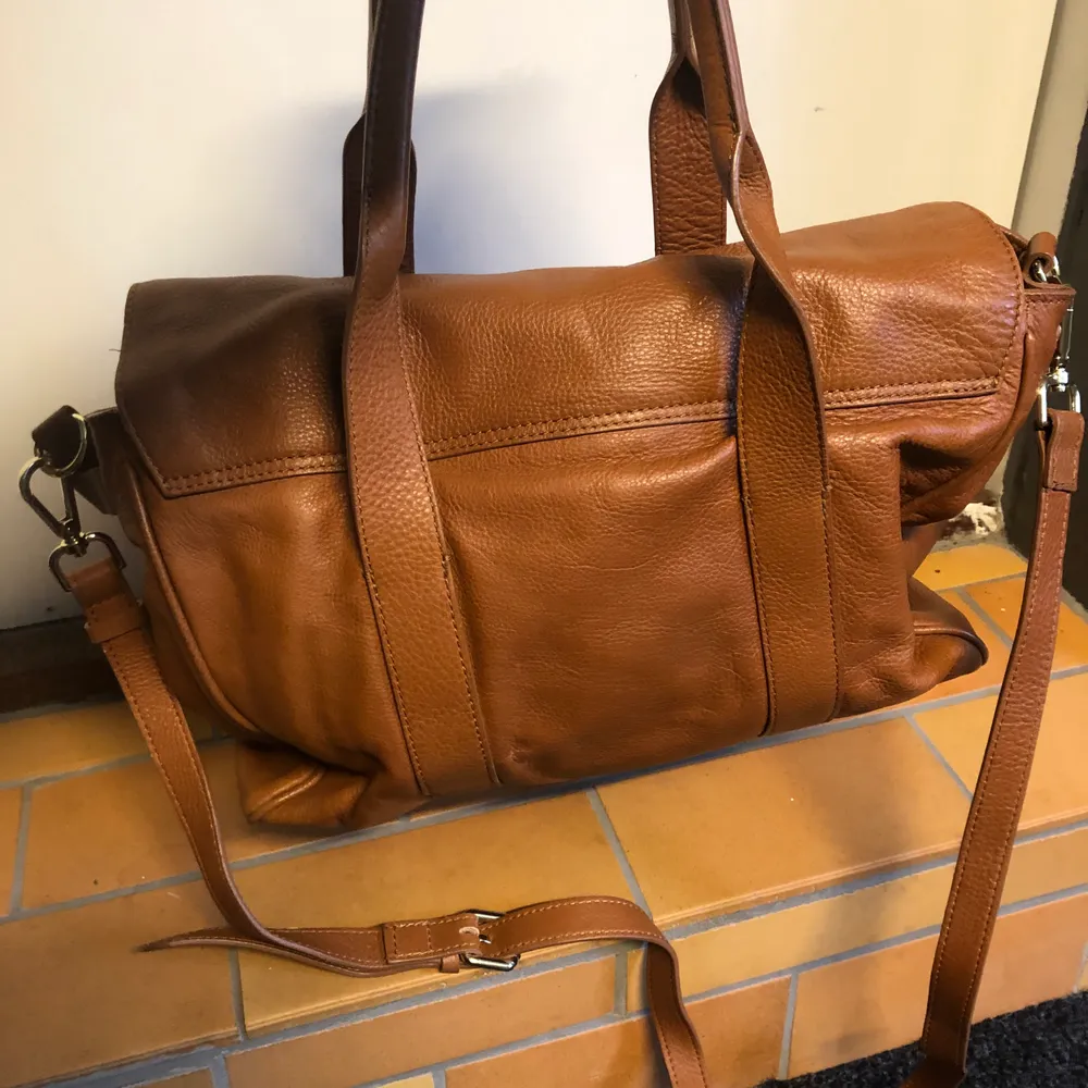 Snygg brun läderväska i fint skick! Man kan använda den både som axelremsväska eller i handen. Fråga gärna efter mått. . Väskor.
