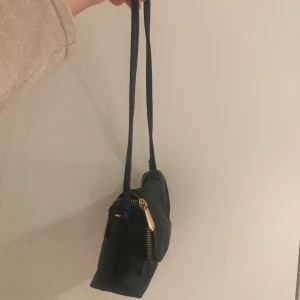 Svart väska - Säljer en skit snygg liten väska som man kan ha på två olika sätt.