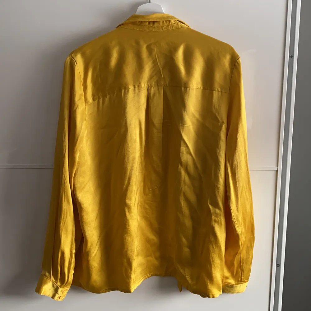 En gul skjorta från nakd. Använd men är i nytt skick. Första bilden är liknande, skillnaden är att på den jag säljer syns inte knapparna när den är knäppt. . Skjortor.