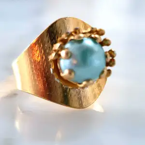 Guldfärgad ring med blå pärla. Supercool att ha med ett par mindre guldfärgaderingar.😇Kontakta vid intresse.