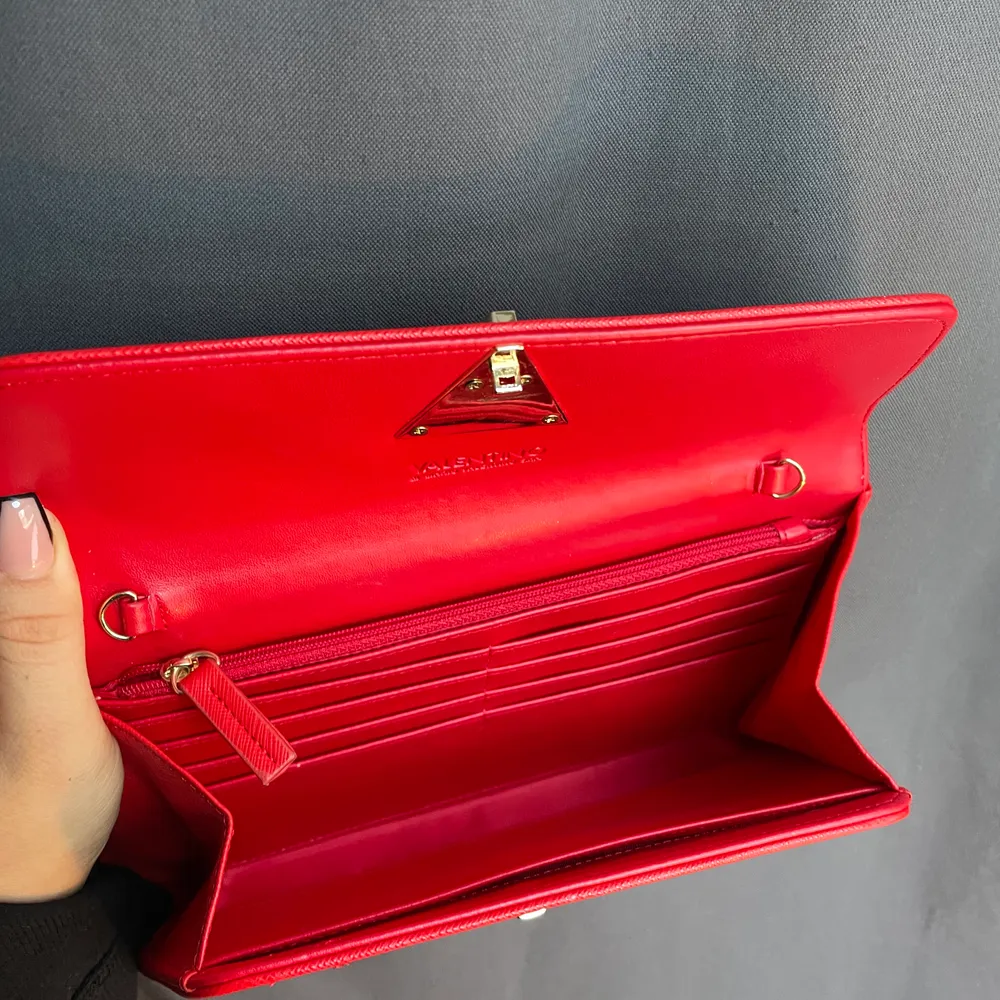 Hej! Säljer denna röda brevformade valentinoväskan p.g.a flytt. Älskar verkligen färgen och de guldiga detaljer, kedjan går att ta bort (se bild två). Perfekt väska till en bal, bröllop eller festande. Det finns mycket förvaring så en plånbok behövs ej😍. Väskor.