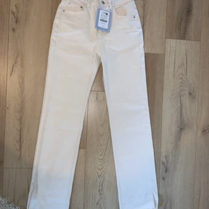 Jeans - Ett par andra splitjeans i en beigeaktig färg. I storlek 36 men passar sannolikt en 34 också.