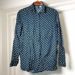 Prickig skjorta - Mörkblå skjortblus med vita prickar. Skrynklig på bilderna efter att ha legat vikt. Väldigt skön att ha på sig🍀