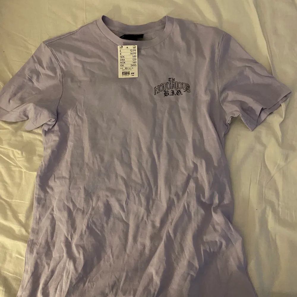 Ljuslila t-shirt med tryck på Notorious b.i.g i storlek xs i modellen regular fit. Helt nu och bara testad i butik. Säljer för att jag inte har någon användning av den men den är som sagt i nyskick. . T-shirts.