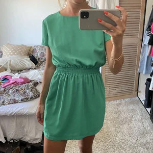 Grön klänning med öppen rygg  - Kort klänning med fin öppen rygg. Härlig grön färg och snygg passform. 