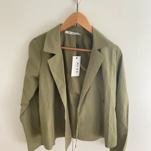 Grön Omlottskjorta Nakd Strl 34 - Säljer denna snygga omlottskjorta från Nakd. Skjortan är i en grön färg i ett typ av blandat linnematerial. Helt oanvänd med prislapp kvar. Pris exklusive frakt 💛