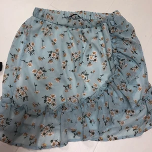 Kjol strl M - En superfin blommig blå kjol i storlek M. Säljer pågrund av att den aldrig kommit till användning. Köpt för 450kr, buda från 150kr :)