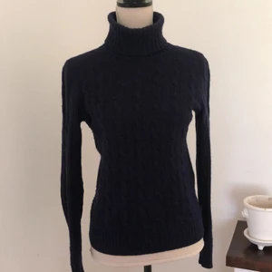 Stickad tröja från Polo Ralph Lauren - Jättefin kabelstickad tröja från Polo Ralph Lauren i mörkblått. Storlek XS, men passar mig som oftast har storlek S. Använd men ändå fint skick. På armbågarna är de brunt mocka. Kan postas men då får du stå för frakten, eller så kan jag mötas upp i Malmötrakterna. 