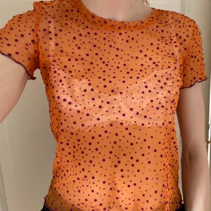 Topp - Orange topp med lila prickar i seethrough. Storlek S. 75 kr inkluderat frakt. Hör av er vid intresse!