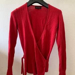 En röd tröja/topp som även går att använda som kofta