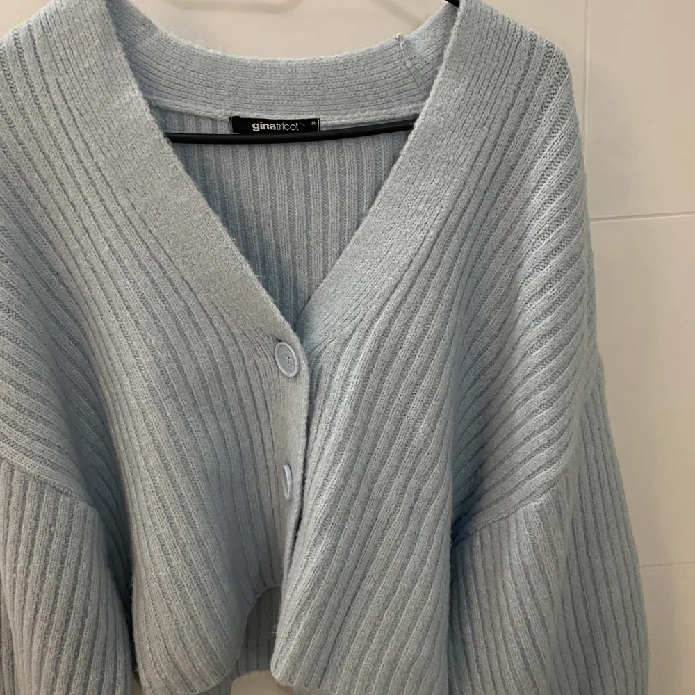 En snygg stickad ljusblå knitted cardigan ifrån Gina tricot. Använd fåtal gånger. Hittade inte exakt samma färg från hemsidan men det är likadan modell. Kan stylas på många olika sätt. Köpt för 349kr. Stickat.
