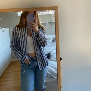 Bomulls skjorta - Blå vit randig skjorta från Bik Bok använd 2 ggr så i väldigt bra skick. Snygg att ha både stängd och öppen. 