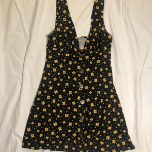 gulblommig klänning  - supersöt svart klänning med gula blommor och vita prickar. säljer eftersom den är lite för kort för min smak (jag är 175) annars sitter den superfint.