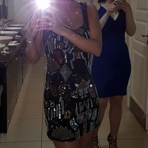 Klänning  - Svart klänning med guld, silver och brons paljetter och stenar.