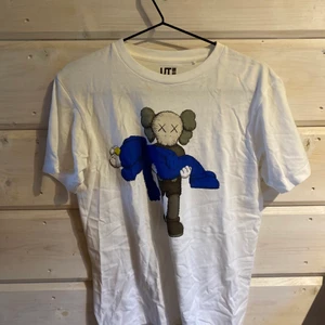 T-shitt Uniqlo x Kaws - T-shirt från Uniqlo kollektionen med Kaws som släpptes 2019 om jag mins rätt. Använd fåtals gånger. Unik kollektion. Kan mötas upp i norrtälje eller Stockholm, eller du du står för frakten😇