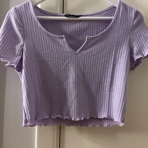 Lila topp - En kort lila topp med en liten öppning där fram 