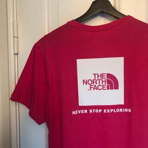 the North Face t-shirt i en snygg rosa färg med BOX-tryck på ryggen. Den är unisex och i storlek S. Knappt använd så därmed i fint skick. Köparen står för frakt! 