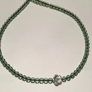 Halsband med gröna glaspärlor  - Handgjort halsband med gröna glaspärlor och en silverfärgad blomma✨Kontakta om du är intresserad✨💚🌸