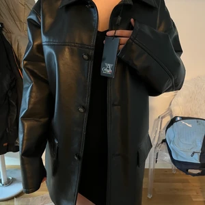 Skinnjacka - Detta är en jättefin lång skinnjacka som är populär och superlätt att styla fin. Den är helt oanvänd och i vanligt bra skick och bra kvalitet. Nypris 1200 men säljer för 600. Den är L men passar mig på ett fint sett enligt mig som är 170