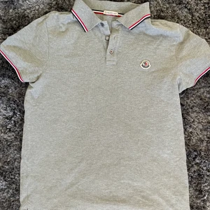 Moncler Piké  - Helt ny moncler piké Stk:M.                                      Den är äkta såklart och inköpt på mythresa.(dm för bevis osv) kvitto finns. Nypris 2000kr pris: 1200kr den är helt oandvänd och endast testad hemma 2/3 ggr 