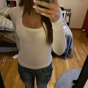 Vit långärmad topp från Pieces - Säljer en snygg och enkel vit långärmad topp från Pieces. Den är ribbad och har en rund halsringning. Toppen är i nyskick och passar till det mesta i garderoben.