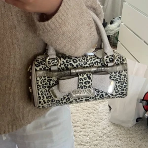 Guess väska - supergullig liten väska i leopardmönster med rosettdetalj Har inga synliga skador🎀, men ändå den här fina vintage känslan. Kommer med tillhörande guess-påse och axelband