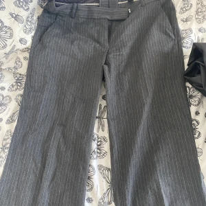 Lågmidjade kostymbyxor - De sitter lågmidjat och snyggt runt rumpan, de är använda men inget som visar det. Säljer den billigt för att jag rensar min garderob / inget fel på.