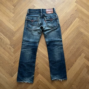 Vintage Levi’s - Jävligt sällsynta och snygga Levis 502 som liknar True Religion med sina flap pockets. Jeansen är tillverkade år 1999 och har distressing som ändå passar och ger dem karaktär.  Hör av er vid ytterligare frågor!
