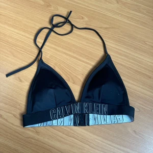 Calvin Klein bikiniöverdel  - Jättefin bikini överdel från Calvin Klein🖤 Använd fåtal gånger, knäppning i ryggen och knytning i nacken  Tyvärr ingen storlek men skulle säga att den passar S/M