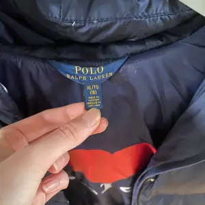 Säljer en snygg och varm mörkblå dunjacka från Polo Ralph Lauren. Den är i strl XL men då Ralph lauren jackorna är extremt små i storlekarna så hade jag jackan när jag var typ 11-12, därefter har den hängt i garderoben. Jackan går ned över rumpan