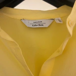 Gul blus från & Other Stories - Säljer en fin blus från & Other Stories i ett lätt och luftigt material. Den har långa ärmar och en smickrande passform med smockdetaljer i midjan. Perfekt för vår och sommar!