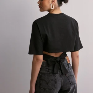 Svart knytblus från Nelly  - Snygg svart blus med knytning i ryggen. Säljer pga den endast kommit till användning ca 5 gånger, där av nyskick. Skriv till mig om ni har frågor💕