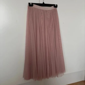Rosa tyllkjol - Säljer en superfin rosa tyllkjol. Kjolen är lång och har ett härligt flöde med flera lager av tyll, den har en elastisk midja. Knappt använd, därav mycket bra skick! Storlek: 148/152 (men passar större storlekar)