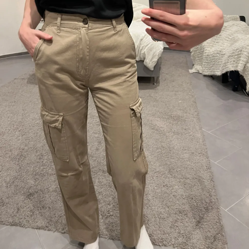 Snygga beige cargopants i mycket bra skick. De har en normal passform och är perfekta för höst och vår. Perfekta för en avslappnad look! Slutsåld på hemsida. Knappt använda!. Jeans & Byxor.