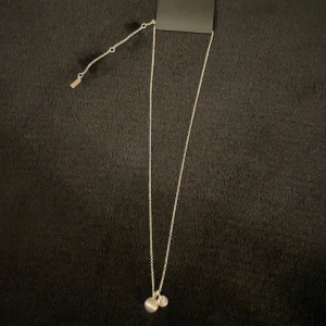 Silverhalsband från Pilgrim - Snyggt silverhalsband från Pilgrim med två hängsmycken, en rund pärla och en pärla med en sten. Halsbandet är justerbart för att passa olika längder. Helt nytt och oanvänt med prislapp kvar. 💕