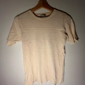 Cremefärgad tshirt - Ny, har aldrig använt! Ganska lång men har super gulliga detaljer!