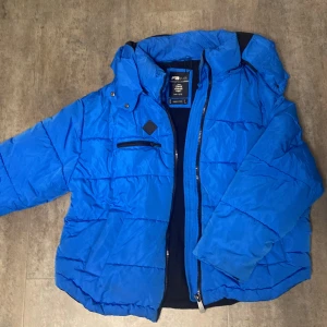 Blå pufferjacka från New yorker  - Säljer en snygg blå pufferjacka från new yorker i storlek L passar i M också eftersom meningen är att den ska vara oversize. Jackan har en dragkedja framtill och en cool patch med texten 'Good Vibes Fresh Vibes'. Perfekt för kalla dagar med sin vadderade design och huva. Passar både till vardags och lite mer avslappnade tillfällen. 🧥💙