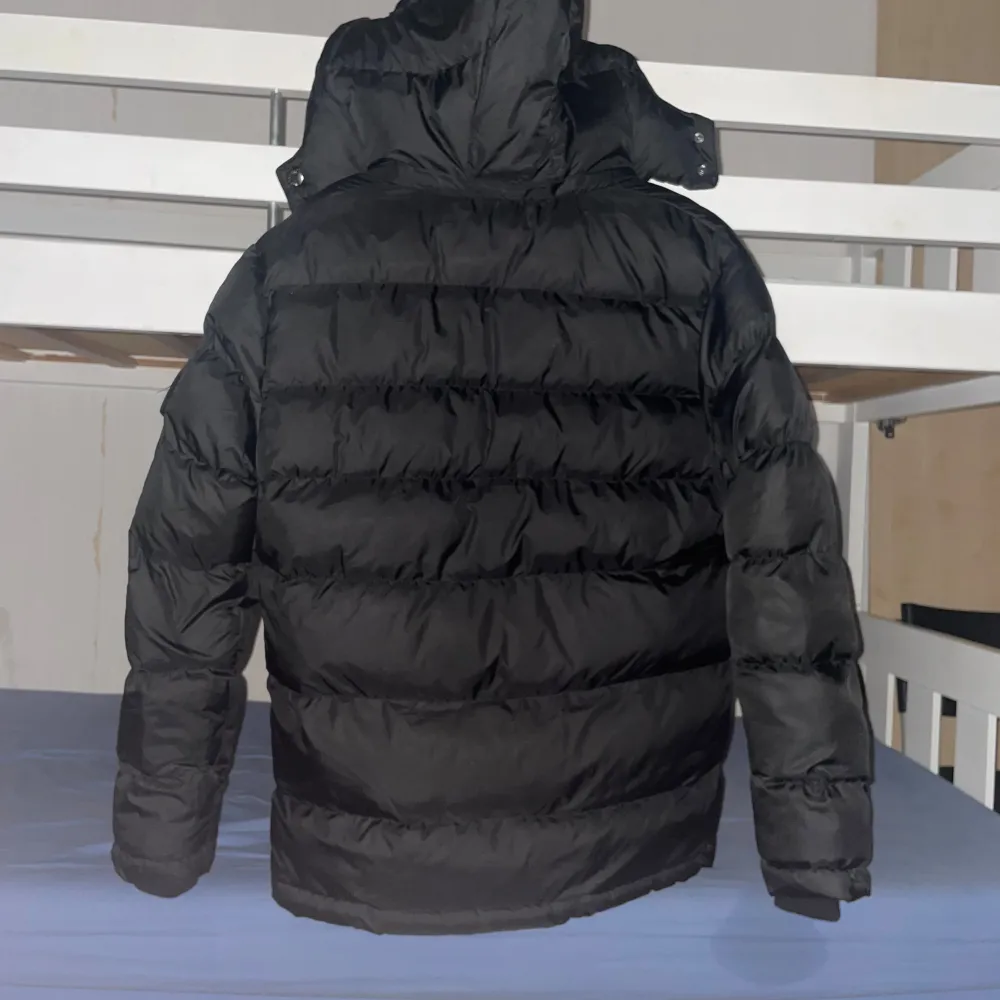 Säljer en snygg svart pufferjacka från Moncler i storlek L. Jackan är i mycket bra skick och perfekt för vintern. Den har en dragkedja framtill och är långärmad. Insidan har en cool serietidningsdesign. Perfekt för att hålla dig varm och stilren i kylan! Den passar M också. Kan gå ner i pris.. Jackor.