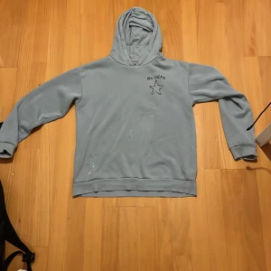 Ljusblå hoodie - Säljer en ljusblå hoodie med texten 'MA CHÉRIE' och en stjärna tryckt på både fram- och baksidan. Säljer då den inte kommer till användning.