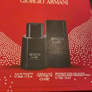 Armani Code Eau de Toilette och Deodorant Stick - Elegant presentförpackning med Armani Code Eau de Toilette (50 ml) och en alkoholfria deodorant stick (75 ml). Flaskan och sticket har en stilren svart design med vit text. Perfekt för den som vill ha en sofistikerad doftupplevelse.