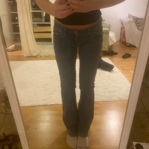 Blå lågmidjade jeans med bootcut från Brandy Melville - Säljer ett par blå jeans med bootcut ifrån Brandy Melville. De har en låg midja och en snygg passform som sitter bra över höfterna.