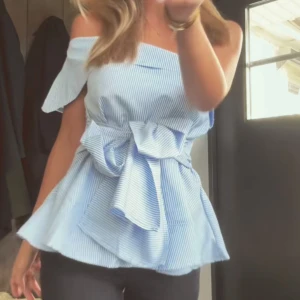 offshoulder-topp - Snygg blå- och vitrandig offshoulder-topp med knytband i midjan. Säljer då den är förstor för mig, den är endast tästad. Köpt för 119kr