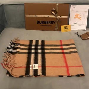 Burberry halsduk - En skitsnygg burberryhalsduk i 100%kashir.  Perfekt för att hålla dig varm under kyliga dagar. Allt OG ingår och den är köpt helt ny för 4800