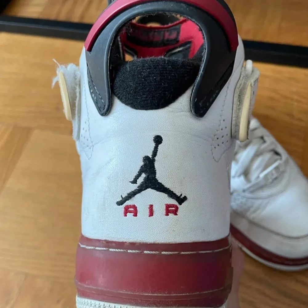 Snygga Nike Air sneakers i vitt med röda detaljer. Skorna har snörning och en hög design med den klassiska Air-loggan på hälen. Perfekta för en sportig look.. Kengät.