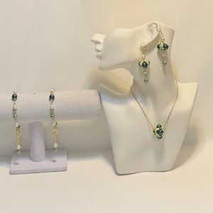 Smyckeset med gröna och vita pärlor - Elegant smyckeset med halsband och örhängen dekorerade med gröna och vita pärlor. Setet har en guldig kedja och detaljer som ger en lyxig känsla. Perfekt för att ge en färgklick till din outfit.