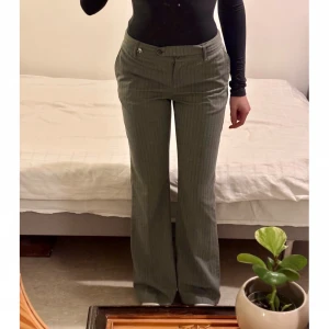 Motivi byxor - Snygga grå Motivibyxor med diskret randigt mönster. Byxorna har en bootcut-stil och är perfekta för en stilren och elegant outfit. Har haft de på mig ksk 1-2 ggr, ord pris 900kr 💕
