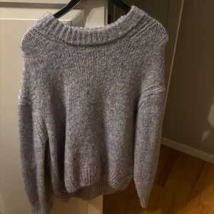 Färgad stickad tröja från Vero Moda - Mysig färgad stickad tröja från Vero Moda. Perfekt för kyliga dagar med sin mjuka och bekväma passform. Tröjan har långa ärmar och en rund halsringning. Den har väldigt vackra färger